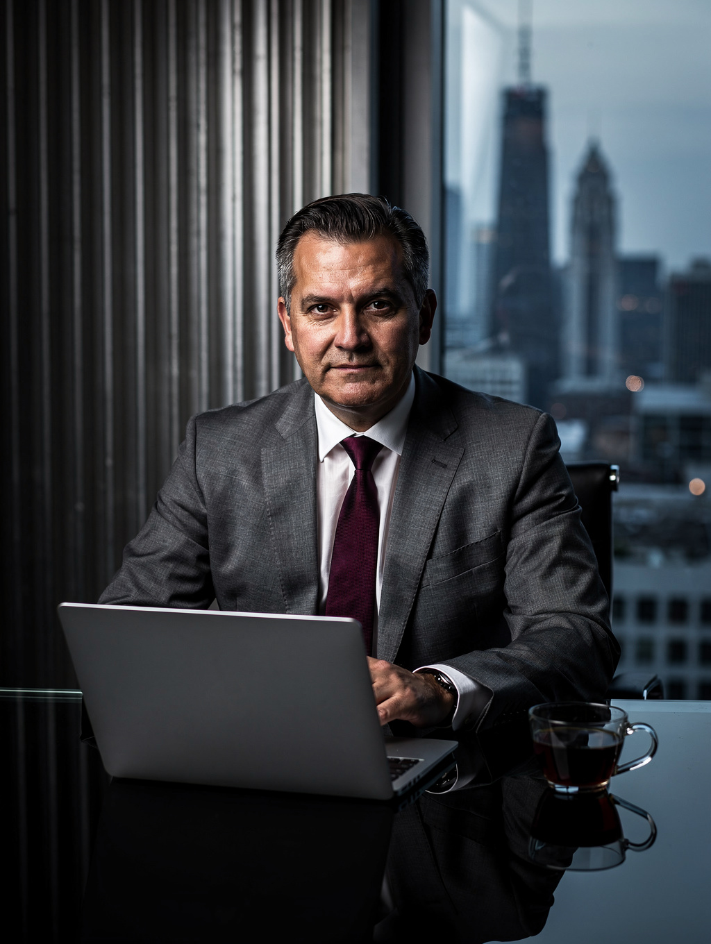 EAL Finance executive at desk in modern office overlooking cityscape